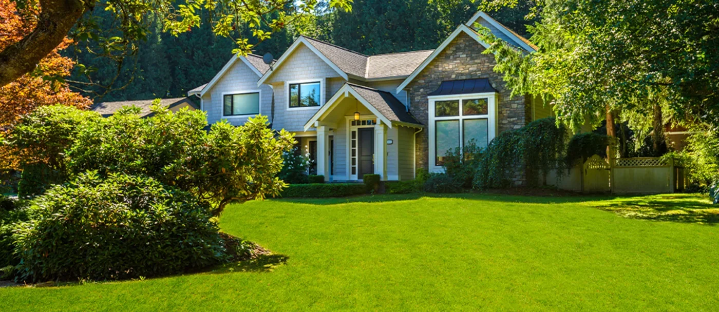 Grande maison avec une magnifique pelouse verte.